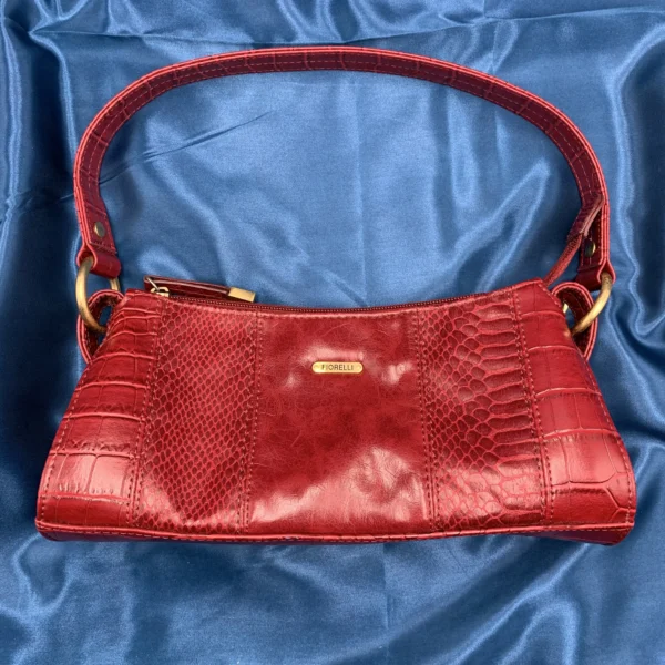 Vintage Fiorelli red shoulder bag with faux croc and snakeskin texture, gold-tone hardware, and zip closure, displayed on a blue satin background.