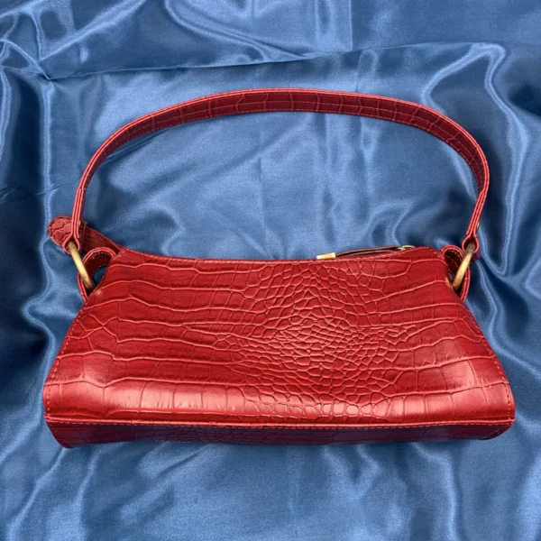 Vintage Fiorelli red shoulder bag with faux croc and snakeskin texture, gold-tone hardware, and zip closure, displayed on a blue satin background.