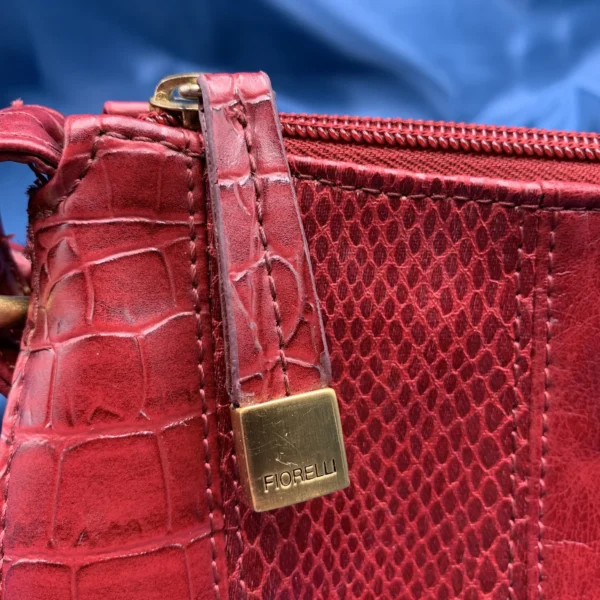 Vintage Fiorelli red shoulder bag with faux croc and snakeskin texture, gold-tone hardware, and zip closure, displayed on a blue satin background.