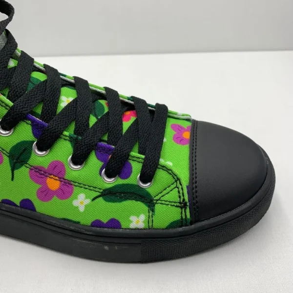 A pair of vibrant Paul Corps green high-top canvas shoes with a colorful floral pattern, black laces, and black soles, showing front side on view.
