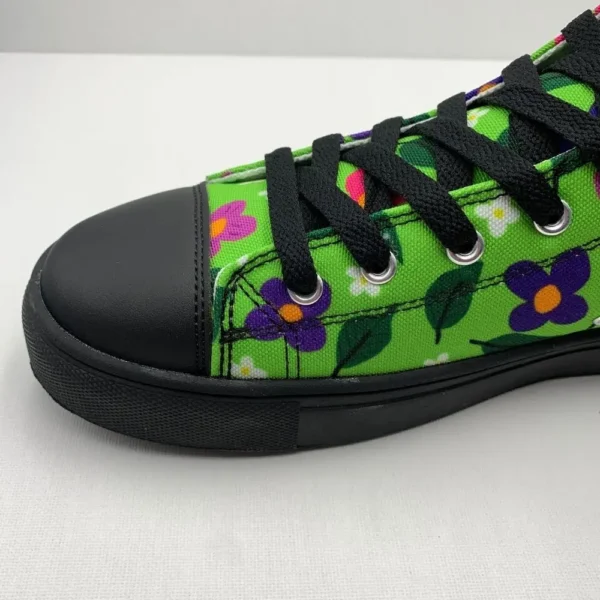 A pair of vibrant Paul Corps green high-top canvas shoes with a colorful floral pattern, black laces, and black soles, showing front side on view.