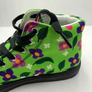 A pair of vibrant Paul Corps green high-top canvas shoes with a colorful floral pattern, black laces, and black soles, showing back side on view.