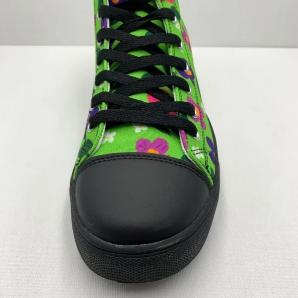 A pair of vibrant Paul Corps green high-top canvas shoes with a colorful floral pattern, black laces, and black soles, showing front toe.
