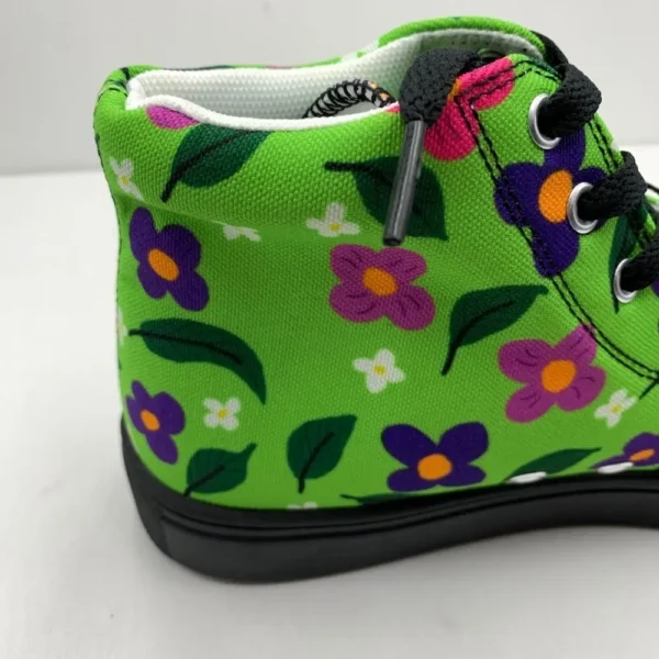A pair of vibrant Paul Corps green high-top canvas shoes with a colorful floral pattern, black laces, and black soles, showing back side on view.