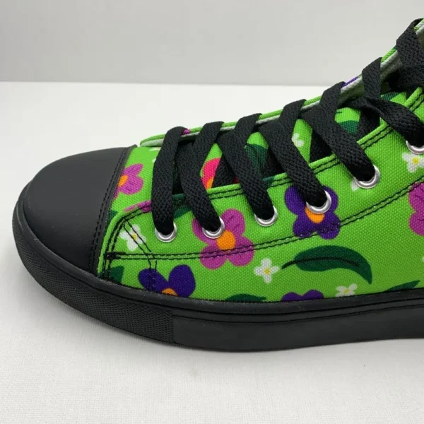 A pair of vibrant Paul Corps green high-top canvas shoes with a colorful floral pattern, black laces, and black soles, showing front side on view.
