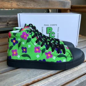A pair of vibrant green high-top canvas shoes with a colorful floral pattern, black laces, and black soles, displayed in front of a white box labeled "Paul Corps."