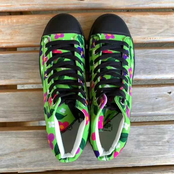 A pair of vibrant Paul Corps green high-top canvas shoes with a colorful floral pattern, black laces, and black soles, view from above.