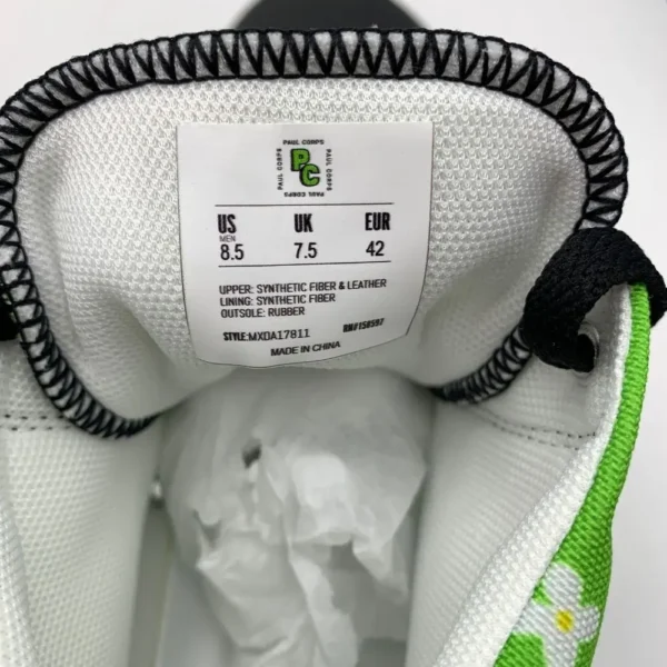 A pair of vibrant Paul Corps green high-top canvas shoes with a colorful floral pattern, black laces, and black soles, showing inside size tag.