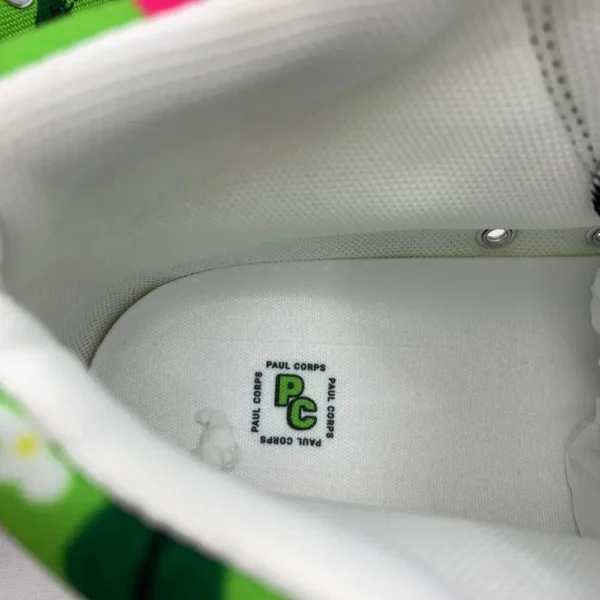 A pair of vibrant Paul Corps green high-top canvas shoes with a colorful floral pattern, black laces, and black soles, showing inside Paul Corps Logo on inner sole.