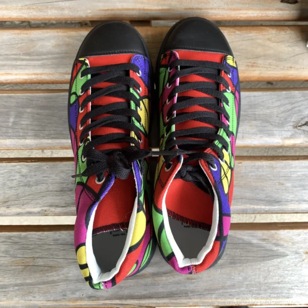 Top-down view of a pair of Paul Corps Lava Lamp Memories high-top canvas shoes with multicolored abstract patterns, black laces, and black toe caps, placed side by side on a wooden bench.