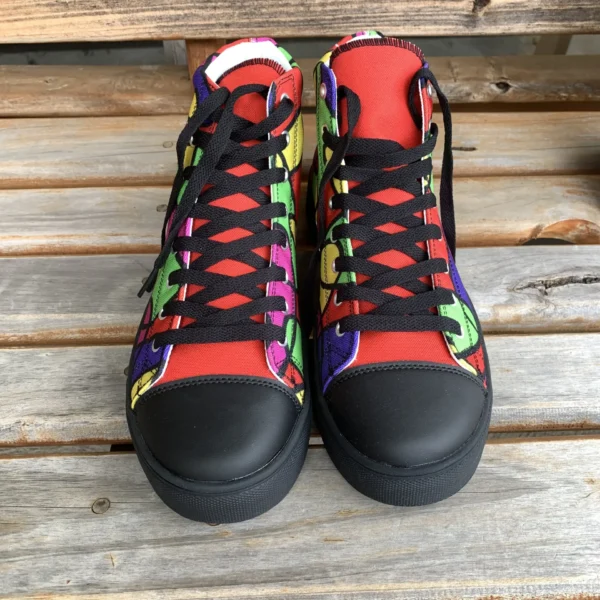 Front view of Paul Corps Lava Lamp Memories high-top canvas shoes, showing both shoes upright with black laces and toe caps, displaying the bold, colorful pattern on a wooden surface.