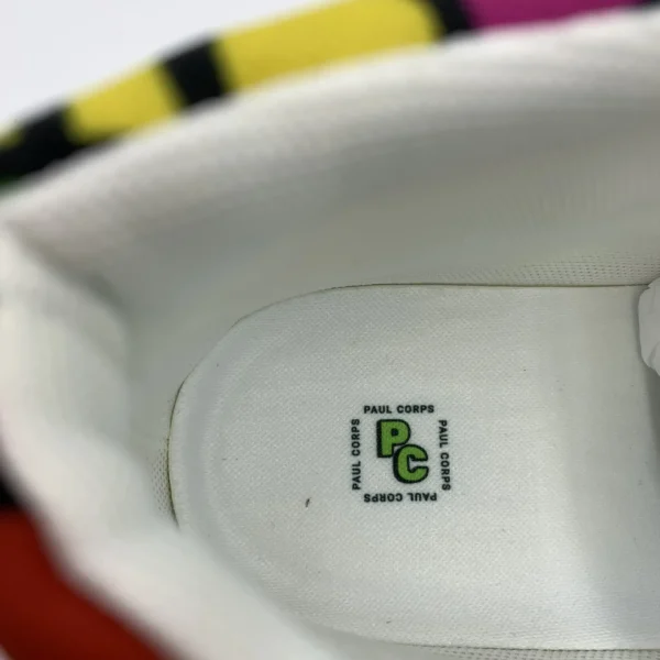 Close-up view of the inside heel of a Lava Lamp Memories high-top canvas shoe by Paul Corps, showing the white insole with the green and black PC logo and branding.