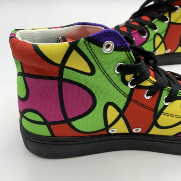 Close-up front view of a Lava Lamp Memories high-top canvas shoe by Paul Corps, focusing on the black toe cap, black laces, and colorful abstract pattern with red, green, yellow, and purple accents.