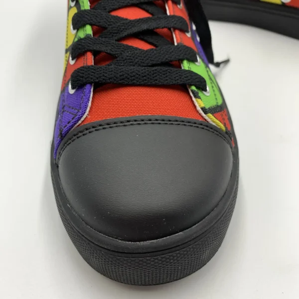 Close-up front view of a Lava Lamp Memories high-top canvas shoe by Paul Corps, showing the black toe cap, black laces, and sections of red, green, yellow, and purple abstract pattern.