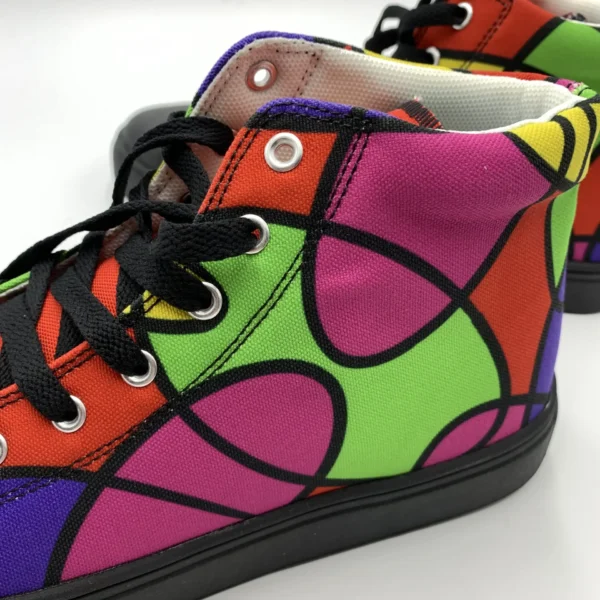 Side close-up of a Lava Lamp Memories high-top canvas shoe by Paul Corps, highlighting the vibrant green, pink, red, and purple abstract pattern with black outlines, silver eyelets, and black laces.