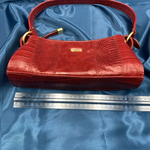 Vintage Fiorelli red shoulder bag with faux croc and snakeskin texture, gold-tone hardware, and zip closure, displayed on a blue satin background.