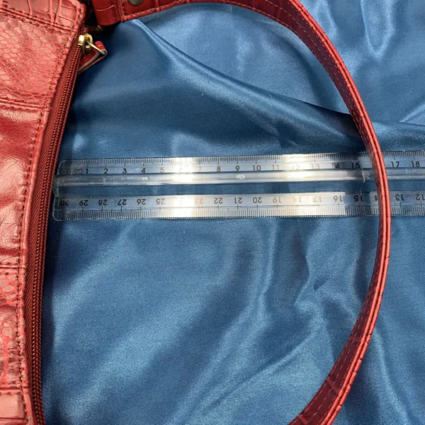 Vintage Fiorelli red shoulder bag with faux croc and snakeskin texture, gold-tone hardware, and zip closure, displayed on a blue satin background.