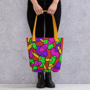A person holding a Lava Lamp Memories all-over print tote bag by the yellow handles, featuring a bold abstract pattern in green, purple, yellow, and pink on a red background, standing against a light speckled wall