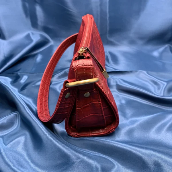 Vintage Fiorelli red shoulder bag with faux croc and snakeskin texture, gold-tone hardware, and zip closure, displayed on a blue satin background.