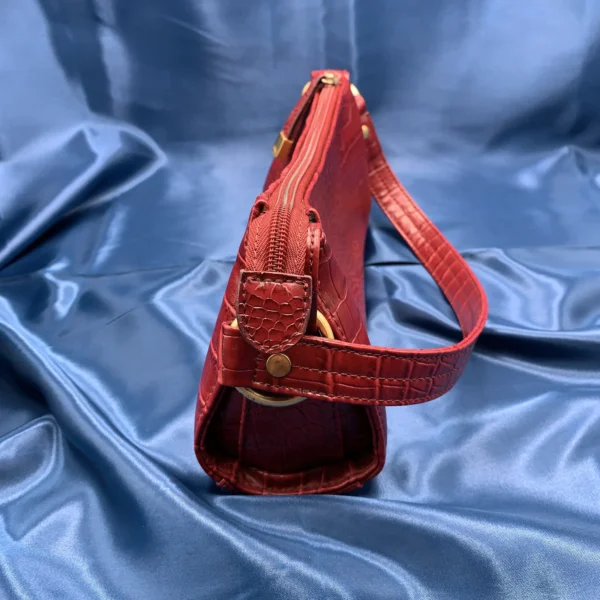 Vintage Fiorelli red shoulder bag with faux croc and snakeskin texture, gold-tone hardware, and zip closure, displayed on a blue satin background.