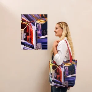 A Paul Corps tote bag featuring a vibrant, digitally enhanced photograph of a Melbourne laneway. The design includes colorful string lights, urban signage, and architectural details in shades of purple, orange, and blue, with black handles.