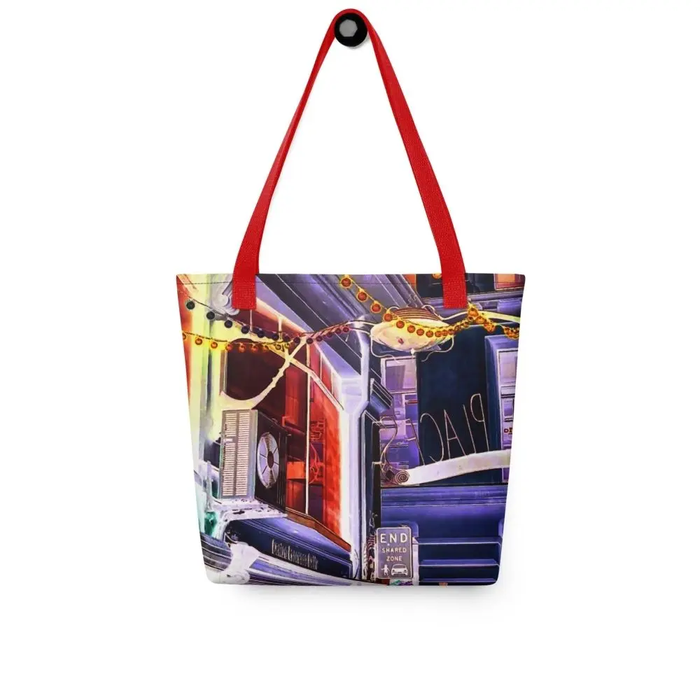 A Paul Corps tote bag featuring a vibrant, digitally enhanced photograph of a Melbourne laneway. The design includes colorful string lights, urban signage, and architectural details in shades of purple, orange, and blue, with black handles.