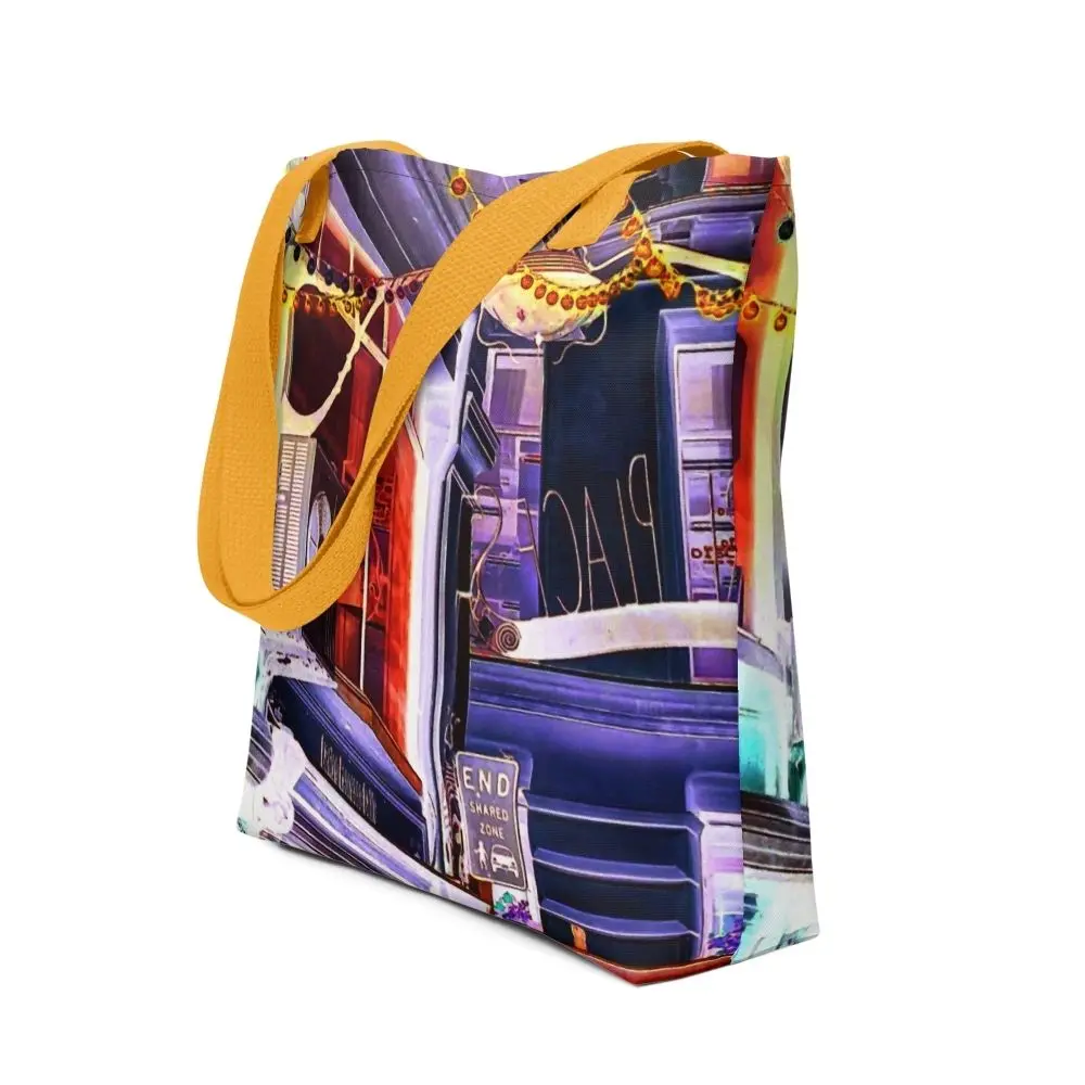 A Paul Corps tote bag featuring a vibrant, digitally enhanced photograph of a Melbourne laneway. The design includes colorful string lights, urban signage, and architectural details in shades of purple, orange, and blue, with black handles.