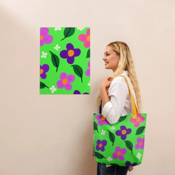A person wearing a Green Spring all-over print tote bag with yellow handles over their shoulder, standing in front of a matching an art print on a beige wall
