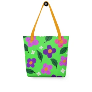 Front view of a Green Spring all-over print tote bag with yellow handles, featuring a bold flower and leaf design in pink, yellow, white and purple, set against a green background