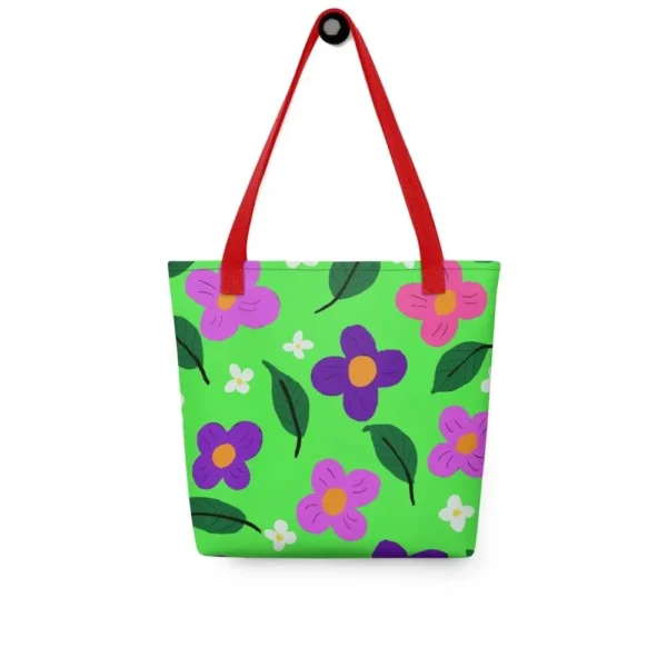 Front view of a Green Spring all-over print tote bag with red handles, featuring a bold flower and leaf design in pink, yellow, white and purple, set against a green background