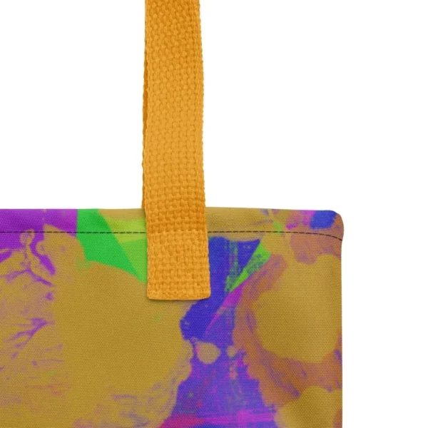 Close-up of the top corner of a Kaleidoscope Dream all-over print tote bag, showing the yellow handle and detailed stitching with the colourful abstract pattern in green, purple, yellow, blue and pink