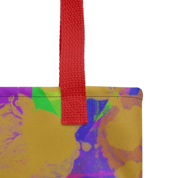 Close-up of the top corner of a Kaleidoscope Dream all-over print tote bag, showing the red handle and detailed stitching with the colourful abstract pattern in green, purple, yellow, blue and pink