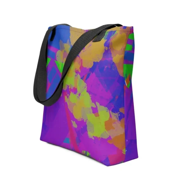 A Kaleidoscope Dream all-over print tote bag with a vibrant abstract pattern in green, purple, yellow, blue and pink, featuring black handles