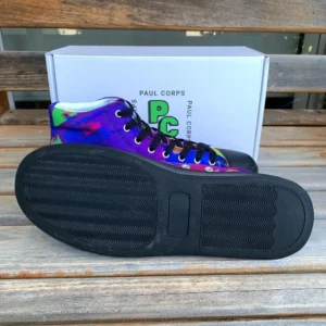 A pair of Paul Corps Kaleidoscope Dream High Top Canvas Shoes featuring a vibrant, abstract pattern in purple, blue, green, and orange, with black laces and black soles, displayed in front of a branded Paul Corps shoe box.