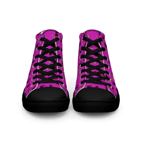 A pair of Paul Corps high-top canvas shoes with a vibrant pink background, decorated with black paw prints and white bone motifs, black laces, and black soles.