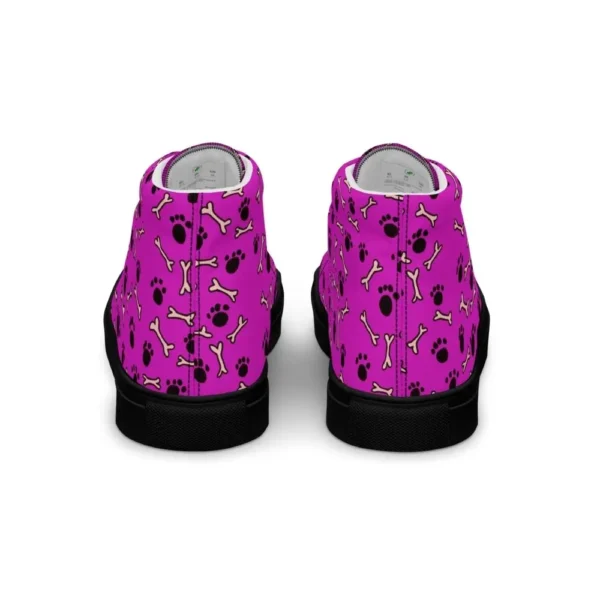 A pair of Paul Corps high-top canvas shoes with a vibrant pink background, decorated with black paw prints and white bone motifs, black laces, and black soles.