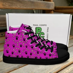 A pair of Paul Corps high-top canvas shoes with a vibrant pink background, decorated with black paw prints and white bone motifs, black laces, and black soles, displayed in front of a white Paul Corps branded box.