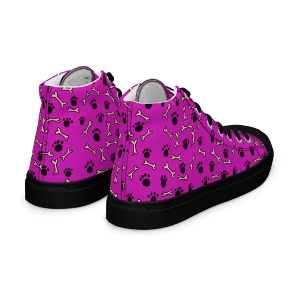 A pair of Paul Corps high-top canvas shoes with a vibrant pink background, decorated with black paw prints and white bone motifs, black laces, and black soles.