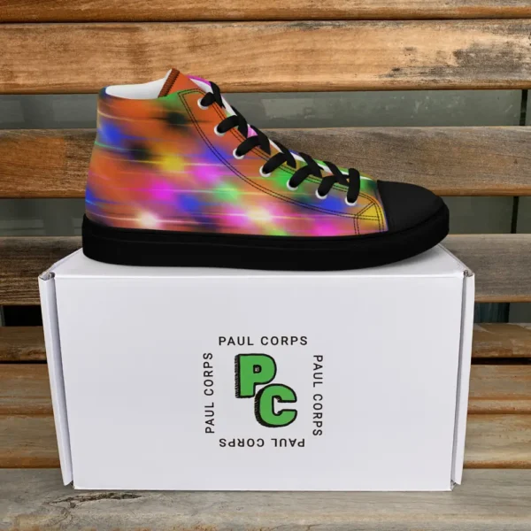 A pair of Paul Corps high-top canvas shoes featuring a bold spray paint-inspired design with vibrant streaks of blue, pink, orange, and yellow, black laces, and black soles, displayed in front of a white Paul Corps branded box.