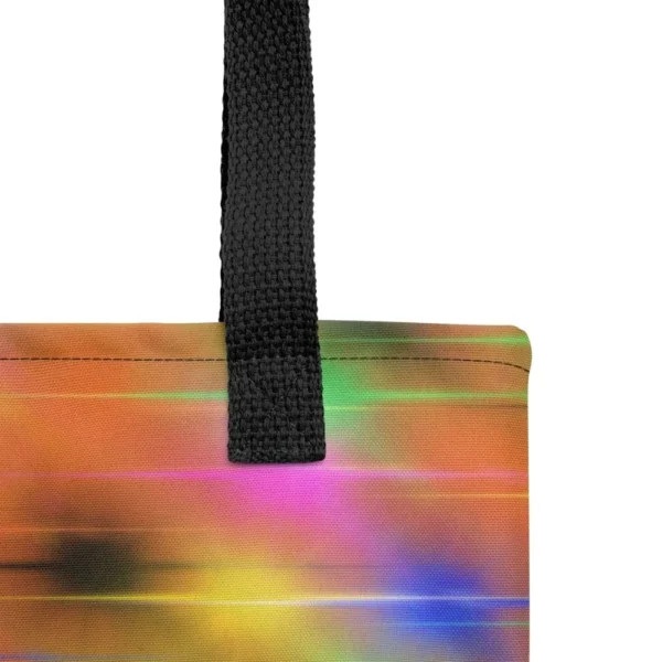 A Paul Corps large tote bag featuring a vibrant spray paint-inspired design with dynamic streaks of blue, pink, orange, and yellow on a black background, finished with sturdy black, red or yellow handles.