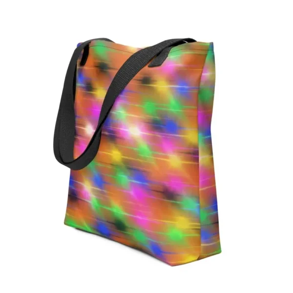A Paul Corps large tote bag featuring a vibrant spray paint-inspired design with dynamic streaks of blue, pink, orange, and yellow on a black background, finished with sturdy black, red or yellow handles.
