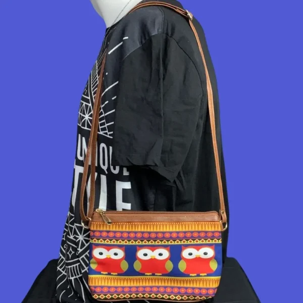 Owl sling bag worn over the shoulder, showcasing compact size and bold artistic design.