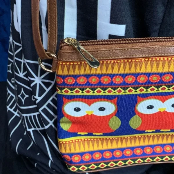 Slim profile of pre-loved owl-themed sling bag showing faux leather sides and adjustable strap.