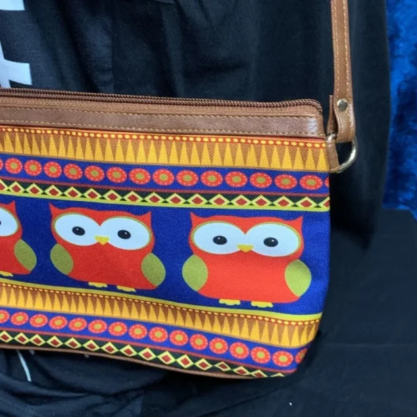 Slim profile of pre-loved owl-themed sling bag showing faux leather sides and adjustable strap.