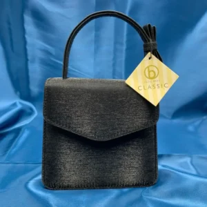 Olga Berg Classic Mini Top Handle Bag in black with original tag, style FC 6489, displayed on blue satin fabric.