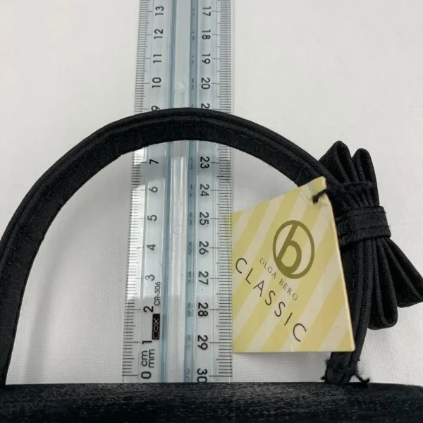 Olga Berg Classic Mini Top Handle Bag in black with original tag, style FC 6489, displayed on blue satin fabric.